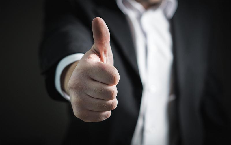 A man with his thumbs up to the camera 