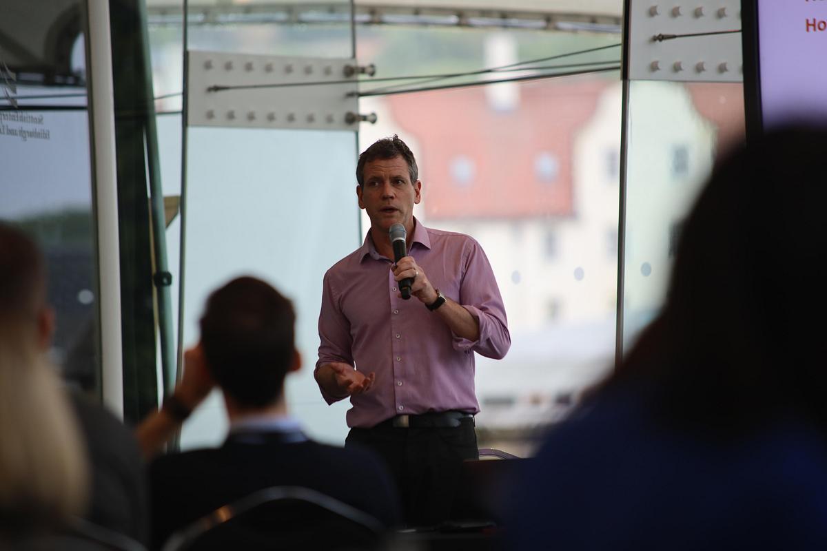 A man presenting to a crowd. 