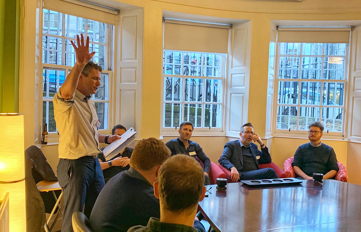 Image of panel discussion with speaker reading out a question