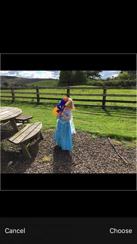 Uploading photo of three year old girl holding a large water pistol and wearing a blue floaty dress like Elsa in Frozen.