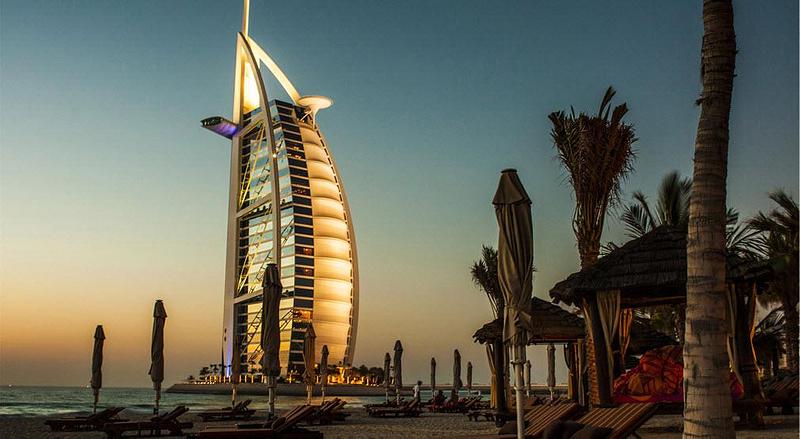 Beach at sunset with a tower building in the background