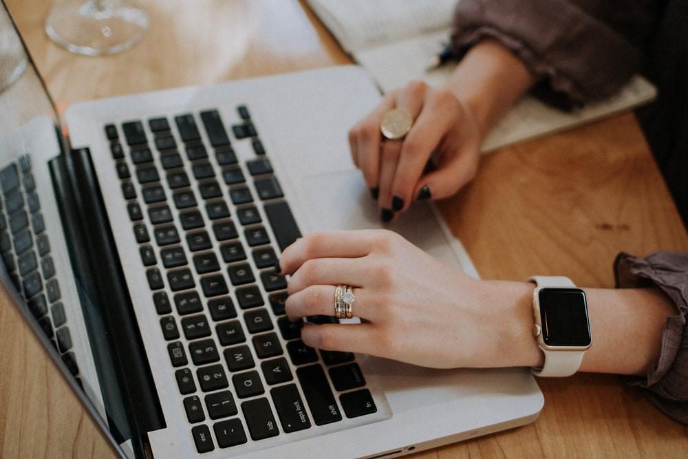 Woman typing oner her Macbook